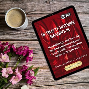 May include: A digital tablet displaying the text "ULTIMATE HOTWIFE HANDBOOK" with additional text about scenarios, captions, and games. A cup of coffee and a bouquet of pink and purple flowers are also on the wooden surface.