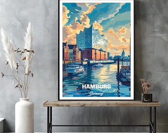 Op de afbeelding: Een ingelijste kunstdruk met een gestileerde illustratie van Hamburg, Duitsland. Het kunstwerk toont de Elbphilharmonie concertzaal, boten op het water en een kleurrijke lucht. De woorden "Hamburg" en "Germany" staan onderaan afgedrukt.