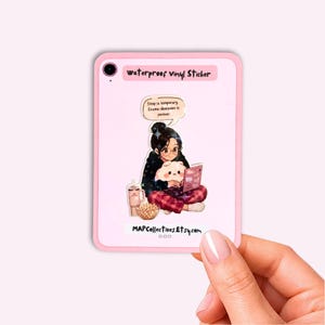 May include: A rectangular waterproof vinyl sticker featuring an illustration of a person with glasses reading a book while holding a plush toy. The text reads: Sleep is temporary. Drama obsession is forever. The sticker also includes a cup and popcorn.