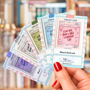 May include: A set of five rectangular magnetic bookmarks featuring a vintage library card design. Each bookmark displays the text I LIKE BIG BOOKS AND I CANNOT LIE in different colors including red, blue, green, purple, and yellow on a grid.
