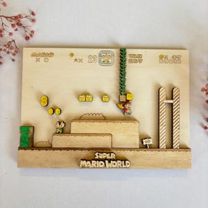 May include: A wooden Super Mario World game board with a 3D design. The board features a green pipe, a question block, a coin, and a character from the game. The board also includes the text "Super Mario World" and the game's score.