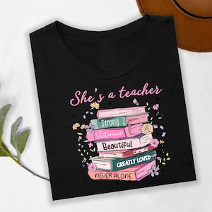 She’s a Teacher Shirt Christian Teacher Bible Verse Tee Faith Strength Encouragement Graphic Book Stack Floral Inspirational TShirt