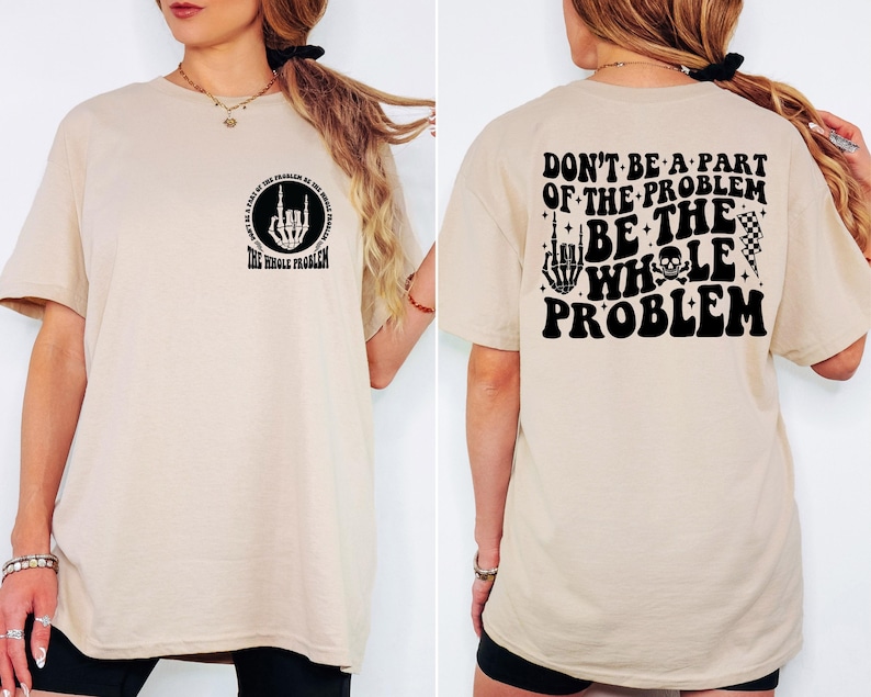 T-shirt featuring a front chest circle design with a skeleton hand and the words “The Whole Problem” surrounding it; the back showcases a large statement reading “Don’t Be a Part of the Problem, Be the Whole Problem” in bold font, with graphic accents like lightning bolts, skulls, and checkered flags. A rebellious and fun shirt for those with an edgy sense of humor — perfect as a gift for bold women or teens with attitude.