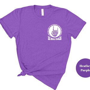 T-shirt featuring a front chest circle design with a skeleton hand and the words “The Whole Problem” surrounding it; the back showcases a large statement reading “Don’t Be a Part of the Problem, Be the Whole Problem” in bold font, with graphic accents like lightning bolts, skulls, and checkered flags. A rebellious and fun shirt for those with an edgy sense of humor — perfect as a gift for bold women or teens with attitude.