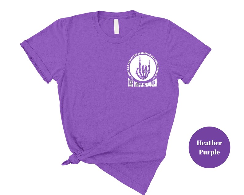 T-shirt featuring a front chest circle design with a skeleton hand and the words “The Whole Problem” surrounding it; the back showcases a large statement reading “Don’t Be a Part of the Problem, Be the Whole Problem” in bold font, with graphic accents like lightning bolts, skulls, and checkered flags. A rebellious and fun shirt for those with an edgy sense of humor — perfect as a gift for bold women or teens with attitude.