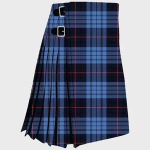 Puede incluir: Un kilt de tartán azul y negro con líneas rojas. El kilt presenta un diseño plisado y dos correas de cuero con hebillas plateadas. La tela tiene un patrón tejido tradicional.