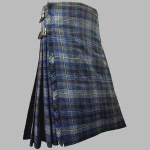 May include: A traditional kilt in a blue, gray, and white plaid pattern. The kilt features pleats, fringe detailing, and leather straps with metal buckles. The fabric has a textured appearance.