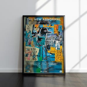 May include: Framed art print of "The New Abnormal" by The Strokes. The artwork features a colourful abstract design with a central figure and text. The print includes song titles and a music player graphic.