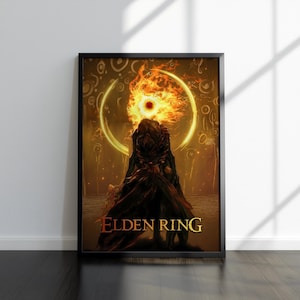 Puede incluir: Póster enmarcado con un diseño ardiente en forma de ojo y un halo dorado, con el texto "ELDEN RING". La obra de arte representa una figura oscura con una cabeza en llamas, sobre un fondo cálido naranja y amarillo. El póster está en un marco negro.