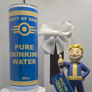 May include: A blue and yellow 20 ounce tumbler with the text "Property of Vault" and "Pure Drinking Water". A blue and yellow keychain with the text "Vault 33" and "If found return to Overseer". A blue and yellow Vault-Tec keychain with a Vault-Tec logo. A blue and yellow figurine of a Vault-Tec dweller with a thumbs up.