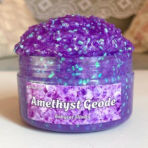 A container labeled "Amethyst Geode by Babycat Slimes" is overflowing with a shimmering purple bingsu slime.