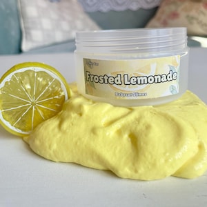 Peut inclure: Une slime jaune avec un pot transparent sur le dessus. Le pot a une &eacute;tiquette qui dit "Frosted Lemonade" et "Babycat Slimes". Une tranche de citron est &agrave; c&ocirc;t&eacute; de la slime.