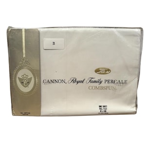 Può includere: Una confezione sigillata di lenzuolo piatto completo bianco Cannon Royal Family Percale Comspun. La confezione ha un'etichetta oro e bianca con la scritta "Cannon, Royal Family Percale Comspun". Il lenzuolo misura 206 x 274 cm.