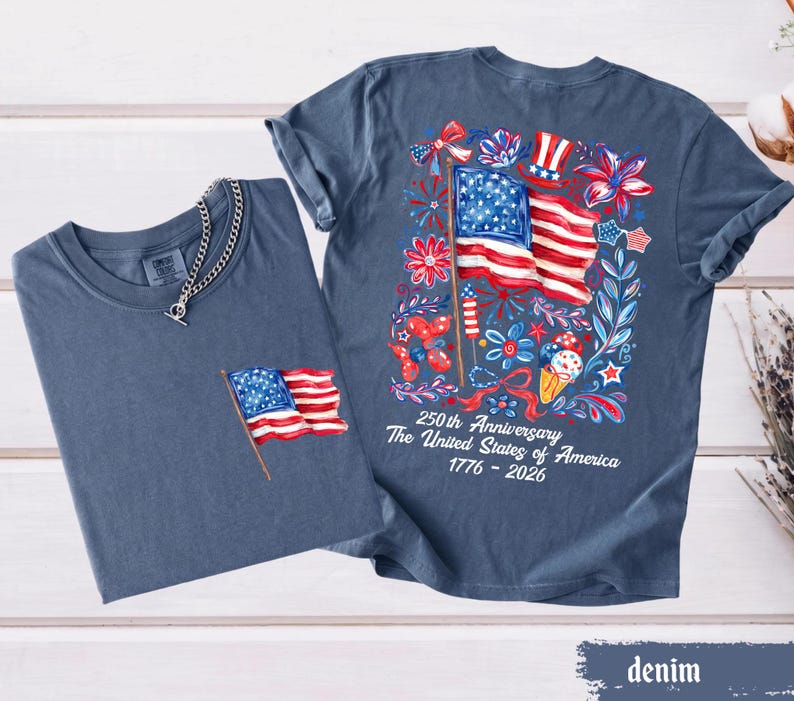 May include: Two denim blue t-shirts. One has a small American flag embroidered on the pocket. The other has a large graphic on the back with an American flag, flowers, and the text "250th Anniversary The United States of America 1776-2026."