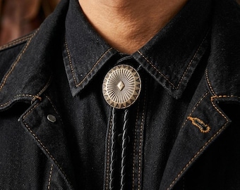 Corbata bolo de latón plateado con concho para hombre, ovalada, grabada, estilo vaquero, para novio o boda, con cordón de cuero ajustable.