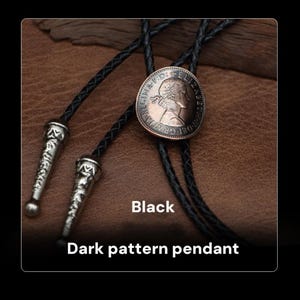 May include: A black bolo tie featuring a circular pendant with a portrait and text. The pendant is attached to black cords with decorative silver-colored tips. The text "Black" and "Dark pattern pendant" are displayed.