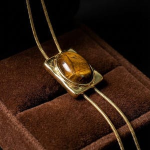 Close view of adjustable chain mechanism allowing the necklace to be styled shorter or longer as a bolo tie.