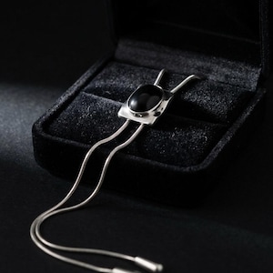 Detail shot of adjustable slider mechanism on a women’s bolo tie necklace, showing flexible Y chain styling and smooth silver finish, designed for comfortable daily wear.