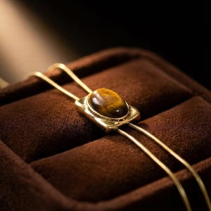 Natural tiger eye gemstone necklace reflecting warm golden brown tones that complement western fashion aesthetics.