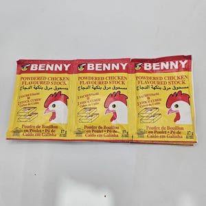 May include: Three yellow packets of Benny powdered chicken flavored stock. Each packet has a red rooster illustration and the text "Powdered Chicken Flavored Stock" in English and Arabic. The text "1 Sachet = 2 Stock Cubes" is also included. The bottom of each packet reads "Poudre de Bouillon en Poulet. Pó de Caldo em Galinha 17g."