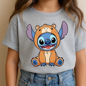 A person wearing a gray t-shirt with a cartoon character printed on it.