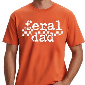 An orange t-shirt with the text "feral dad" printed on it.