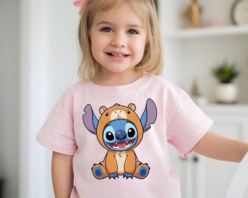 A young girl wearing a pink t-shirt with a cartoon character printed on it.