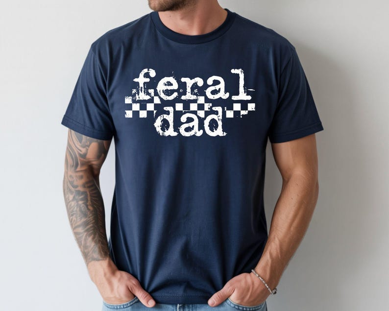 A man wearing a navy blue t-shirt with the text "feral dad" printed on it.