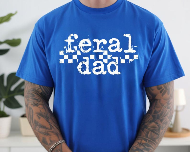 A person wearing a blue t-shirt with the text "feral dad" printed on it.