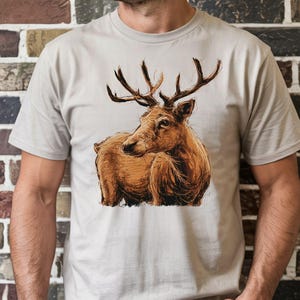 A man is wearing a white t-shirt with a printed image of a deer on it.