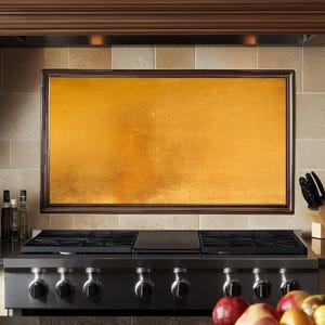 May include: A stainless steel gas stovetop with five knobs and a black cast iron griddle. The stovetop is installed in a kitchen with a gold-colored backsplash.