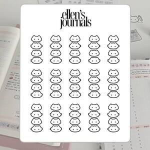 May include: A sheet of stickers featuring a repeating pattern of stylized cat faces. The stickers are black and white, with the text "ellen's journals" at the top. The stickers are designed for use in journals and planners.