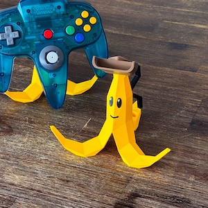 May include: A white ceramic mug with a black handle and the text "But First, Coffee" in a bold, black font. The mug is set against a blurred background, suggesting a cosy setting.