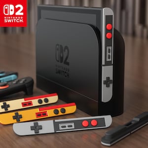 Könnte beinhalten: Eine schwarze Nintendo Switch-Konsole mit abnehmbaren Controllern in verschiedenen Farben, darunter Gelb, Rot und Grau. Die Konsole zeigt das Nintendo Switch-Logo und Controller-Tasten. Das Bild zeigt die Konsole und die Controller auf einer Holzoberfläche.