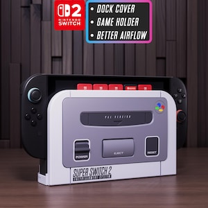 Puede incluir: Una cubierta de base Super Switch 2 blanca y gris para la Nintendo Switch. La cubierta de la base tiene un diseño retro con el texto "Super Switch 2 Entertainment System". La imagen también muestra una consola Nintendo Switch y cartuchos de juego.