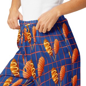 May include: Blue pajama pants with a repeating pattern of corn dogs on a red and blue grid.