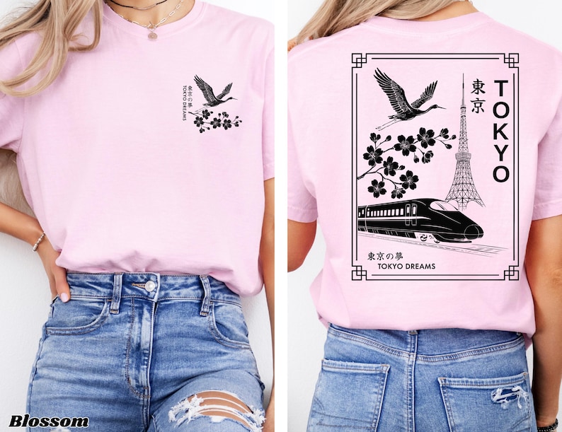 May include: Pink t-shirt with a black graphic design featuring a crane, cherry blossoms, a Tokyo Tower, and a bullet train. The text "TOKYO" and "東京" are also included in the design. The text "東京の夢 TOKYO DREAMS" is at the bottom of the design.