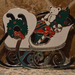 Salvamanteles grande Wm A Rogers con forma de trineo, 24 x 19 cm, esmaltado, le faltan dos patas de goma, incluye percha.
