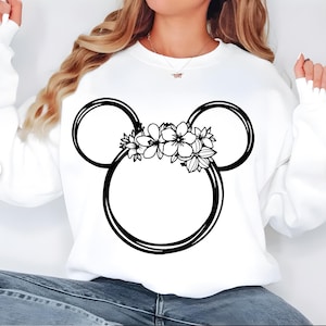 May include: White sweatshirt featuring a black Mickey Mouse head design with floral accents. The design includes two large circles for ears and a central circle, all outlined in black, with a floral arrangement at the top.