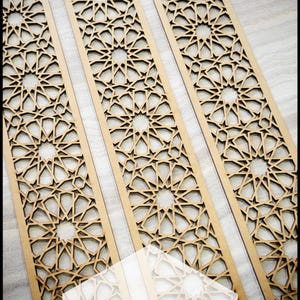 May include: Four wooden custom trim panels with intricate geometric star patterns. The panels are light brown and arranged vertically. The text "CUSTOM TRIM PANELS" is overlaid on the image.