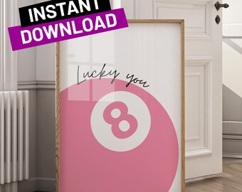 May include: Pink and white 8-ball with the text "Lucky you" in black cursive writing. The 8-ball is in the center of the image and is surrounded by a pink background.
