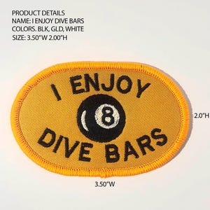 May include: An oval embroidered patch with a gold background and a gold stitched border. The text I ENJOY DIVE BARS is embroidered in black, with a black 8-ball graphic in the center. The patch measures 3.50 inches wide by 2.00 inches high.