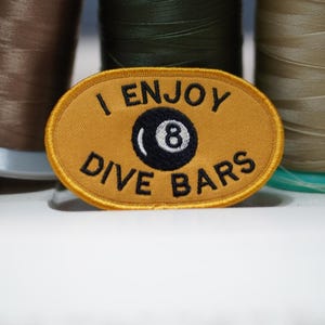 May include: A white ceramic mug with a black handle and the text "But First, Coffee" in a handwritten style. The mug is on a white surface. The mug is approximately 4 inches tall.