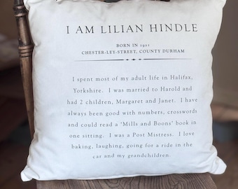 May include: White square pillow with black text. The text reads "I AM LILIAN HINDLE" and includes biographical details: born in 1921, lived in Halifax, Yorkshire, married Harold, had children, and enjoyed baking and grandchildren.