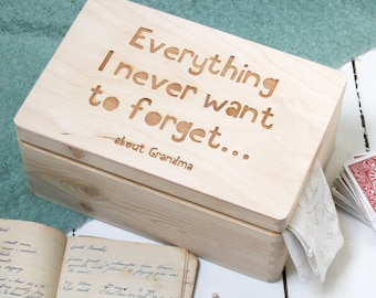 May include: A wooden box with a lid that has the words "Everything I never want to forget... about Grandma" engraved on it. The box is sitting on a white surface.