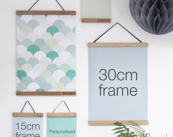 May include: Four wooden frames with black hanging cords. The frames are 15cm, 30cm, and two personalized sizes. The frames are hanging on a white wall with a gray honeycomb ball decoration. The frames are empty and ready for artwork.