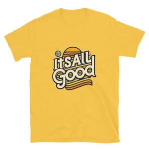 Könnte beinhalten: Gelbes T-Shirt mit kurzen Ärmeln und einem Retro-Grafikdruck mit der Aufschrift "It's All Good" mit einem Peace-Zeichen und einem Sonnenuntergangs-Motiv.