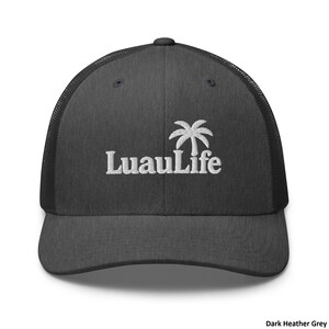 May include: Dark heather grey trucker hat with a white embroidered "LuauLife" logo and a palm tree graphic. The hat has a mesh back and a curved brim. The text "Dark Heather Grey" is at the bottom right.