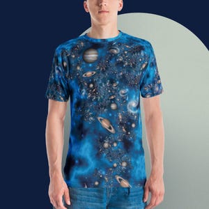 以下が含まれることがあります： 惑星と星が描かれた銀河柄の青いTシャツ。半袖でクルーネックです。