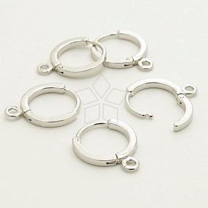 Könnte beinhalten: Vier silberne Ohrring-Verschlüsse mit Scharnierverschluss und einem Sprungring. Die Verschlüsse sind zum Anbringen an Schmuck gedacht.